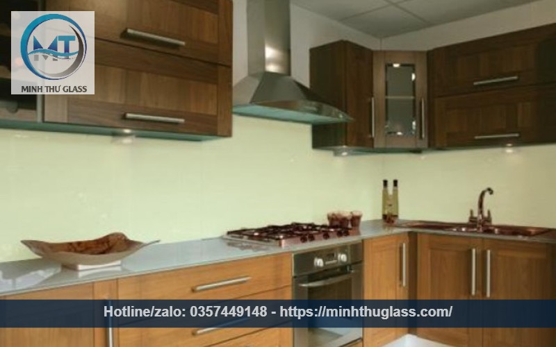 Kính ốp bếp màu kem sữa với tủ nâu trầm sang trọng