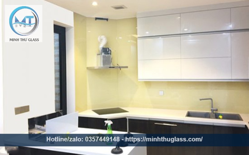 Kính ốp bếp màu kem sữa kết hợp tủ trắng hiện đại